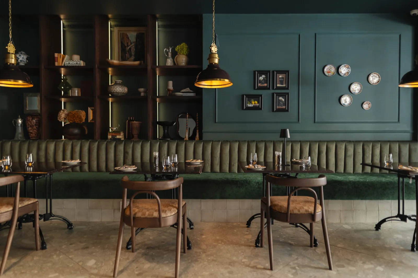 Noah Cape Town dining room with forest-green banquette seating and warm pendant lighting